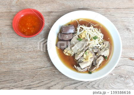 boiled slice duck meat with liver and blood in black soybean herb soup on plate dipping spicy sour chili sauce boiled slice duck meat with liver and blood in black soybean herb soup on plate dipping spicy sour chili sauce 139386616