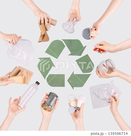 Hands holding different household waste around recycling symbol Hands holding different household waste around recycling symbol 139386714