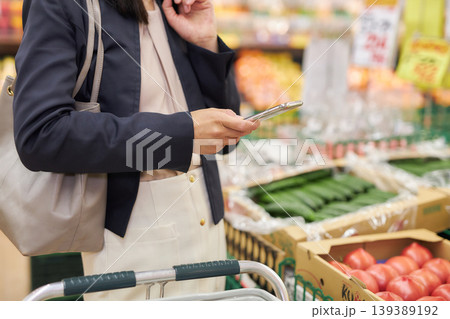 仕事帰りにスーパーマーケットで買い物をする若い女性 仕事帰りにスーパーマーケットで買い物をする若い女性 139389192