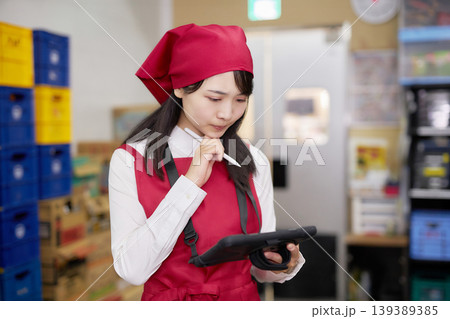 バックヤードでタブレットで商品管理をする若い女性 139389385