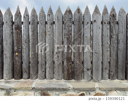 Wooden fence made of sharp pointed boards Wooden fence made of sharp pointed boards 139390121