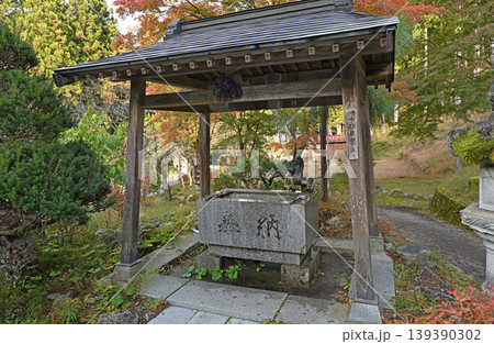 静寂に包まれた手水舎 紅葉する木々と伝統的な木造建築が織りなす秋の境内 静寂に包まれた手水舎 紅葉する木々と伝統的な木造建築が織りなす秋の境内 139390302