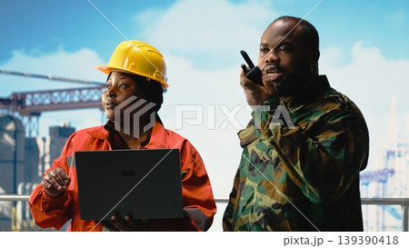 Soldier working on offshore platform communicating via military radio. Naval unit boarding drilling barge under maritime interdiction protocol, speaking on tactical walkie talkie Soldier working on offshore platform communicating via military radio. Naval unit boarding drilling barge under maritime interdiction protocol, speaking on tactical walkie talkie 139390418