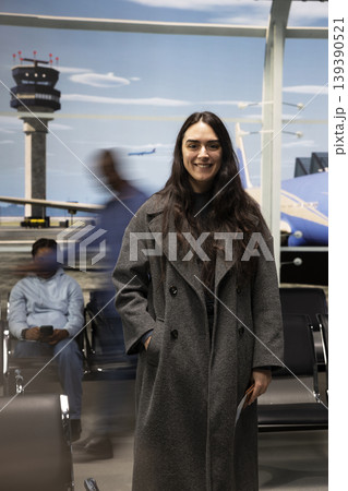 Portrait of joyful woman in airport traveling to dream destination, fast paced motion blur people in background. Upbeat girl excited about holiday trip next to hectic crowd, busy lifestyle concept 139390521