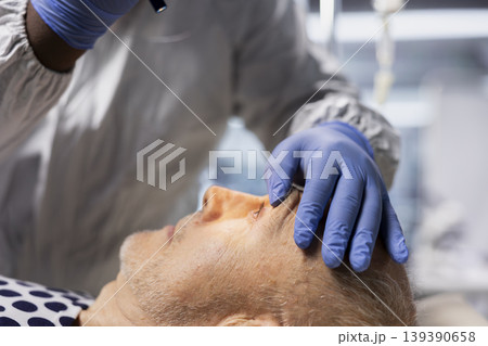 Close up of expert in biohazard lab checking vitals on infected patient, quarantine to contain contagious disease transmission and antiviral drug effectiveness to develop treatments in virology. 139390658