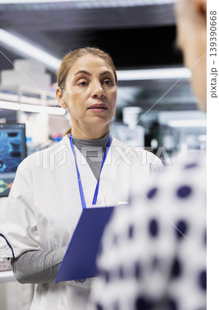 Female doctor checking vitals for a patient during clinical trial and testing, using a light pen for research procedure. Gathering pharmacology data for innovative healthcare breakthrough. Female doctor checking vitals for a patient during clinical trial and testing, using a light pen for research procedure. Gathering pharmacology data for innovative healthcare breakthrough. 139390668