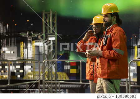 Drone tech used by offshore platform crew coworkers for aerial surveillance of maritime waters. Drilling ship teamworking colleagues monitoring oil spills with UAV during aurora borealis night Drone tech used by offshore platform crew coworkers for aerial surveillance of maritime waters. Drilling ship teamworking colleagues monitoring oil spills with UAV during aurora borealis night 139390693