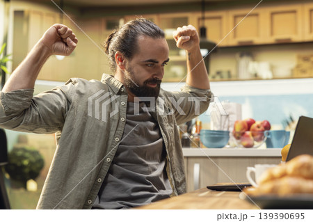 Job satisfaction, overjoyed man with ambition, promotion as a reward, excited person celebrating good news, victory with positive emotion. Uplifting authentic reaction at home. Job satisfaction, overjoyed man with ambition, promotion as a reward, excited person celebrating good news, victory with positive emotion. Uplifting authentic reaction at home. 139390695