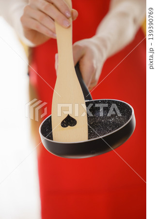 Woman hand holding cooking pan and spatula Woman hand holding cooking pan and spatula 139390769