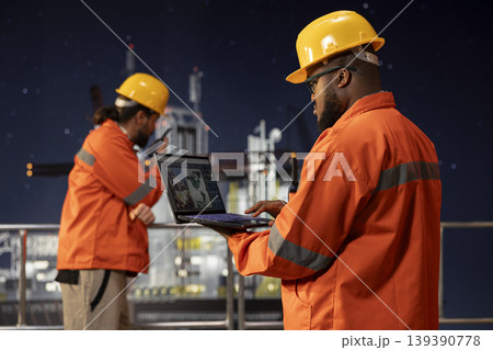 Offshore platform engineer uses laptop to review geological survey data on digital mapping interface. African american man evaluating seabed topography maps for site assessment planning 139390778