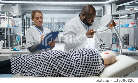 Magnifying glass used by research institute team to study a patient during drug testing in laboratory, collect data on dosage and side effects to contribute to pharmacology development. Camera A. 139390826