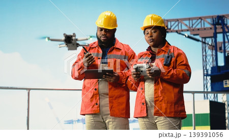 Drilling rig engineering team using drone to access areas that pose environmental risks to humans. Offshore platform coworkers use remote control UAV to conduct aerial surveys Drilling rig engineering team using drone to access areas that pose environmental risks to humans. Offshore platform coworkers use remote control UAV to conduct aerial surveys 139391056