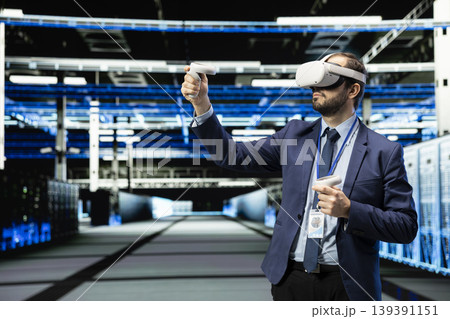 Using VR headset gear, technology and programmer in data center managing enterprise technology solutions. Supervising IT operations, virtual reality simulation and employee in futuristic server room 139391151