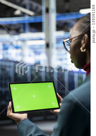Evaluating hardware, green screen tablet and engineer in data center reading diagnostic reports. Automating supercomputers processing, mockup device and IT specialist in server hub Evaluating hardware, green screen tablet and engineer in data center reading diagnostic reports. Automating supercomputers processing, mockup device and IT specialist in server hub 139391169