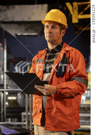 Professional male engineer on offshore platform ensure drilling management with reports, integrating industrial maritime technology to obtain natural gas and fossil fuels. Oil industry. 139391224