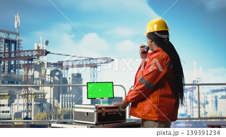 Isolated screen tablet used by drilling rig expert to monitor systems, talking in handheld radio. Offshore platform technician using walkie talkie, calibrating gear with chroma key device, Isolated screen tablet used by drilling rig expert to monitor systems, talking in handheld radio. Offshore platform technician using walkie talkie, calibrating gear with chroma key device, 139391234