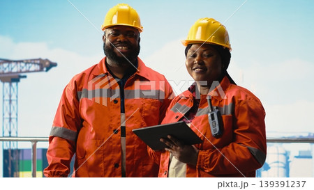 Happy offshore platform engineering team monitoring operations on oil production barge. Joyous drilling rig ship crew wearing safety gear reviewing energy operations Happy offshore platform engineering team monitoring operations on oil production barge. Joyous drilling rig ship crew wearing safety gear reviewing energy operations 139391237