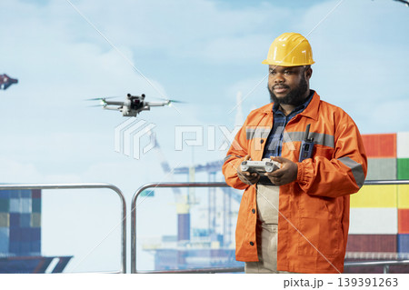 Drilling rig engineer using drone to access areas that pose health risks to humans from safe distance. Worker uses remote control UAV to conduct aerial inspection of offshore platform Drilling rig engineer using drone to access areas that pose health risks to humans from safe distance. Worker uses remote control UAV to conduct aerial inspection of offshore platform 139391263