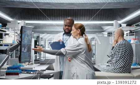 Doctors in a clinical research procedure examining DNA results on monitor, consulting a patient and studying reactions of new pills. Analyzing dosage outcomes to ensure treatment safety. Camera A. 139391272