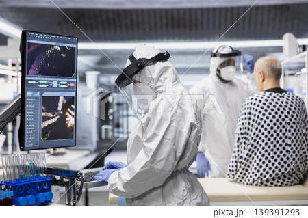 Medic in protective gear collecting data on infection spread, observing symptoms of patient in isolation and quarantine. Analyzing antibiotics and antiviral therapy for disease control. Medic in protective gear collecting data on infection spread, observing symptoms of patient in isolation and quarantine. Analyzing antibiotics and antiviral therapy for disease control. 139391293