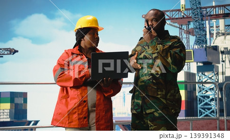 Soldier working on offshore platform communicating via military radio. Naval unit boarding drilling barge under maritime interdiction protocol, speaking on tactical walkie talkie, 139391348