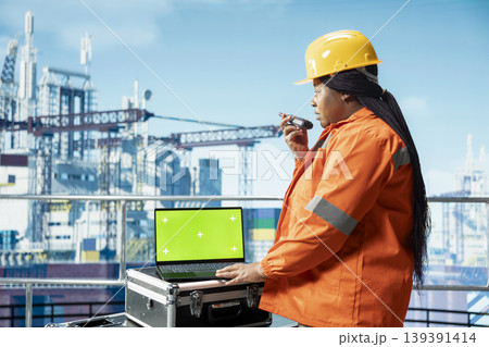 Green screen laptop used by offshore platform worker configuring boat management systems for more efficient oil extraction. Engineer working on drilling rig doing seabed analysis using mockup notebook 139391414