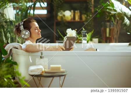 Woman\'s Serene Bath Time with Headphones and Tablet 139391507