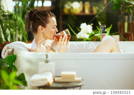 Tranquil Bath: Sipping Liquid in Lush Setting Tranquil Bath: Sipping Liquid in Lush Setting 139391521