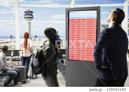 All flights cancellation, unhappy passengers, red alerts on board screen, flights grounded due to strike or conflict. Diverse group shows panic, anger and frustration, uncertain travel plans. 139391548