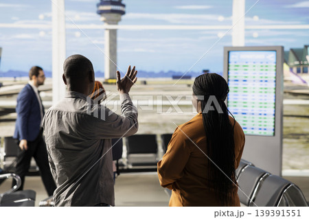 Mother and father waving goodbye during emotional farewell with teen daughter at airport gate. Teenager foreign student boarding the airplane, international flight for university abroad. Mother and father waving goodbye during emotional farewell with teen daughter at airport gate. Teenager foreign student boarding the airplane, international flight for university abroad. 139391551