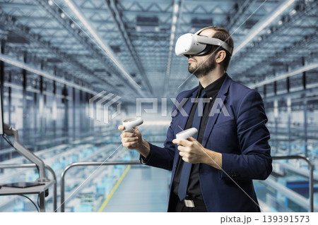 Man reviews microchips factory analytics with VR headset gear on elevated platform. Manager uses virtual reality tech, monitoring automated semiconductor production in industry 4.0 manufacturing plant 139391573