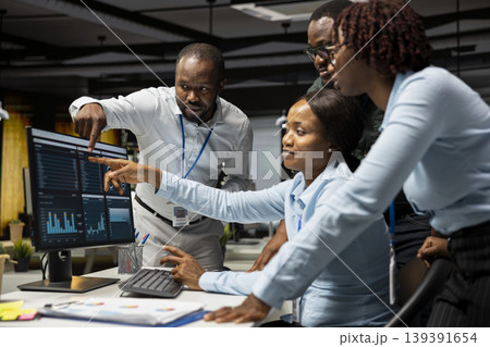 Black team of finance specialists reviewing data reports on computer, building a vision and business strategy to accomplish objectives and success. Professional mindset late at night. 139391654