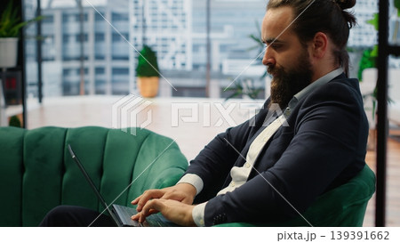 Entrepreneur transferring money online using his credit card and PC, handling financial matters efficiently to achieve success. Male CEO managing all his payments before deadline. Camera B. 139391662
