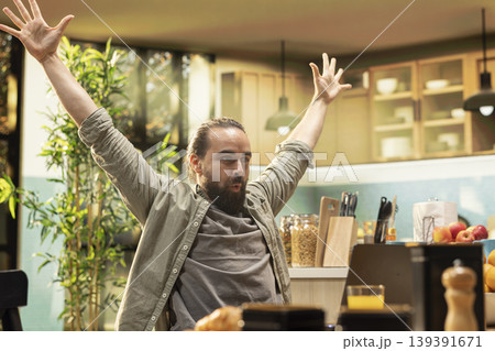 Pleased excited man being overjoyed after receiving a promotion, uplifting good news for ambitious confident employee at home. Happy male with satisfaction and gratitude, enjoyment. Pleased excited man being overjoyed after receiving a promotion, uplifting good news for ambitious confident employee at home. Happy male with satisfaction and gratitude, enjoyment. 139391671