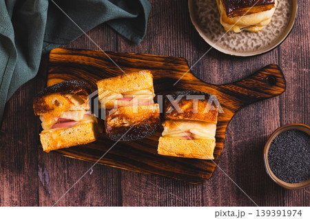 Baked buns with cheese, sausage and poppy seeds on a board on the table top view Baked buns with cheese, sausage and poppy seeds on a board on the table top view 139391974