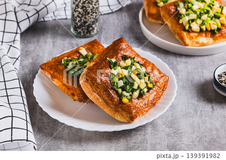 Mini puff pastry tarts with egg and green onions on a plate on the table Mini puff pastry tarts with egg and green onions on a plate on the table 139391982