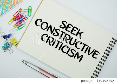 Seek Constructive Criticism text message written on notepad with stationery flat lay on white background Seek Constructive Criticism text message written on notepad with stationery flat lay on white background 139392152