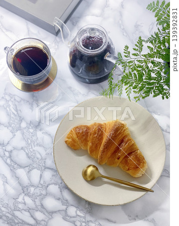 窓際の明るい光の中で楽しむコーヒーとクロワッサンの朝食風景 窓際の明るい光の中で楽しむコーヒーとクロワッサンの朝食風景 139392831