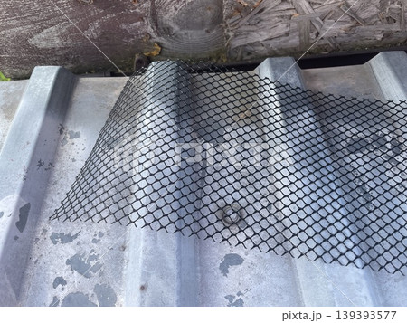 Installing leaf guard mesh in gutter Installing leaf guard mesh in gutter 139393577