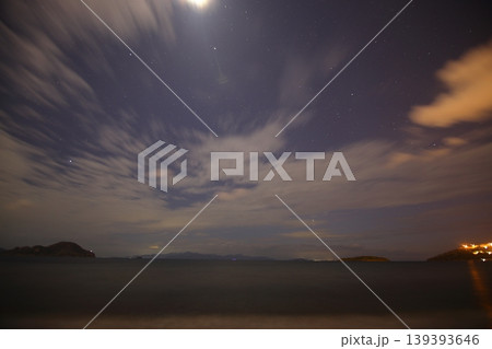 Moonlit Aegean Sea Night with Stars, Greek Island Silhouette and Calm Deep Blue Water Background 139393646