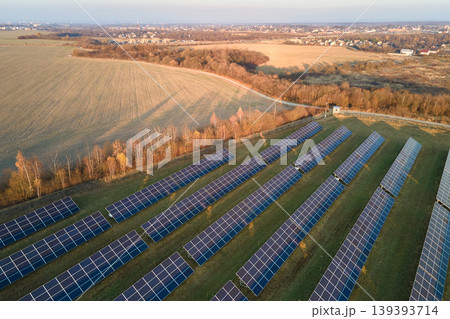 Aerial view of large sustainable electrical power plant with rows of solar photovoltaic panels for producing clean ecological electric energy. Renewable electricity with zero emission concept Aerial view of large sustainable electrical power plant with rows of solar photovoltaic panels for producing clean ecological electric energy. Renewable electricity with zero emission concept 139393714