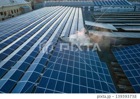 Aerial view of blue photovoltaic solar panels mounted on industrial building roof for producing green ecological electricity. Production of sustainable energy concept Aerial view of blue photovoltaic solar panels mounted on industrial building roof for producing green ecological electricity. Production of sustainable energy concept 139393738