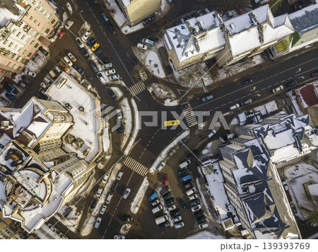 Aerial black and white winter top view of modern city with tall buildings, parked and moving cars along streets with road marking. Urban cityscape, view from above. Aerial black and white winter top view of modern city with tall buildings, parked and moving cars along streets with road marking. Urban cityscape, view from above. 139393769