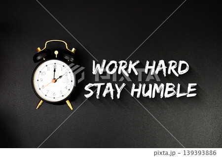 Work Hard Stay Humble text with alarm clock on black background Work Hard Stay Humble text with alarm clock on black background 139393886
