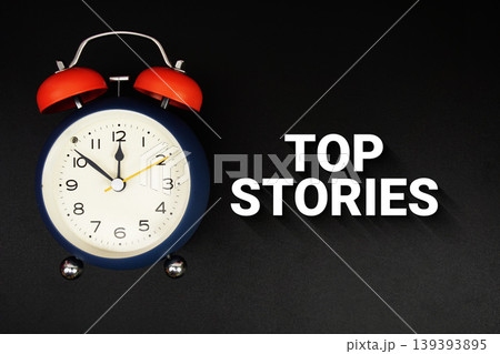 Top Stories text with alarm clock on black background 139393895