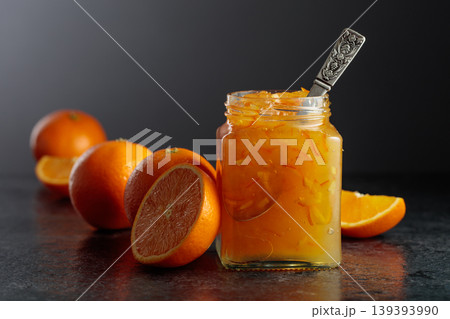 Homemade orange jam in a glass jar on a black table. Homemade orange jam in a glass jar on a black table. 139393990
