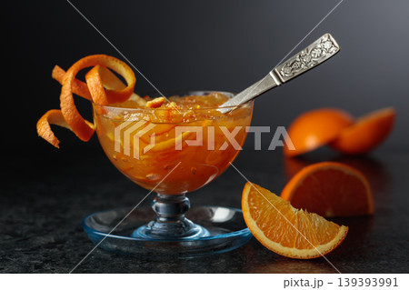 Homemade orange marmalade in a glass bowl garnished with irange pell. Homemade orange marmalade in a glass bowl garnished with irange pell. 139393991