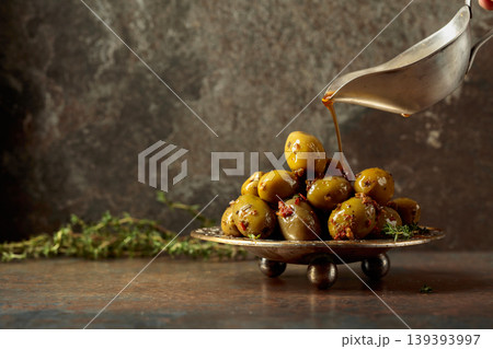 Spicy green olives are poured with olive oil with spices. Spicy green olives are poured with olive oil with spices. 139393997