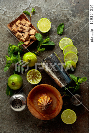 Wooden citrus squeezer, shaker, and ingredients for making summer refreshing drinks. Wooden citrus squeezer, shaker, and ingredients for making summer refreshing drinks. 139394014