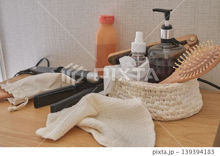Hair styling tools and beauty products on wooden dresser Hair styling tools and beauty products on wooden dresser 139394183
